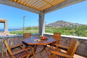 een houten tafel en stoelen op een patio met uitzicht bij Michaela Beach Houses in Mithimna