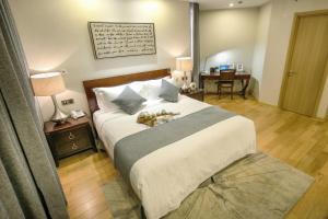 a bedroom with a large bed and a table with a desk at Green Court Residence Jinqiao Diamond Shanghai in Shanghai