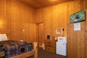Schlafzimmer mit einem Bett, einer Mikrowelle und einem Kühlschrank in der Unterkunft Teton Valley Cabins in Driggs