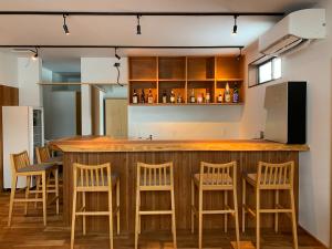 uma cozinha com um bar com bancos de madeira em やどバーTATSUJi em Joetsu