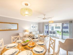 a dining room and living room with a table and chairs at Kristie Court 3 7 Weatherly Close with air con and close to the beach in Nelson Bay