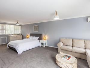 a bedroom with a bed and a couch at Kristie Court 3 7 Weatherly Close with air con and close to the beach in Nelson Bay