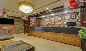 a lobby with a counter with clocks on the wall at Treebo Trend Golden Heights in Jamshedpur