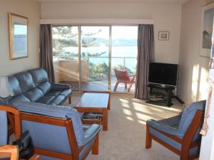 a living room with a couch and a television at Charming Beach Getaway, Close to Cafe & Restaurant in Terrigal