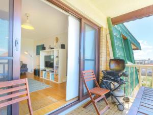 a room with a balcony with a television and a chair at Kingsway Apartment 12 in Kingscliff