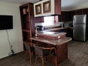 a kitchen with a counter with chairs and a refrigerator at The Villa - Amazingly Comfortable King Beds in Alpine