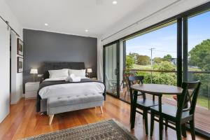 a bedroom with a bed and a table and a balcony at Avalon House in Eden