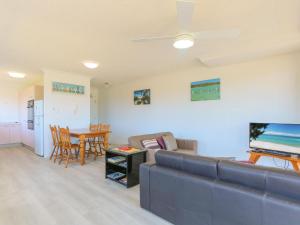 a living room with a couch and a table at Acacia Holiday Apartment in Kingscliff