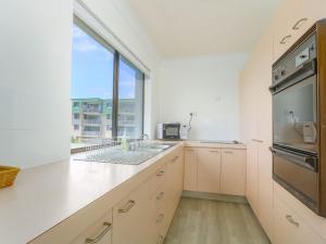 a kitchen with a sink and a large window at Acacia Holiday Apartment in Kingscliff