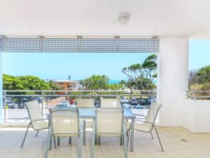 a dining room with a table and chairs on a balcony at Azura Ocean View Holiday Apartment in Kingscliff