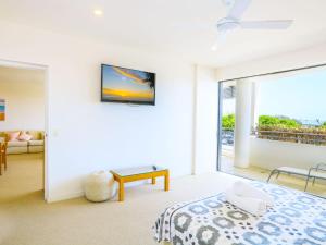 a bedroom with a bed and a sliding glass door at Azura Ocean View Holiday Apartment in Kingscliff