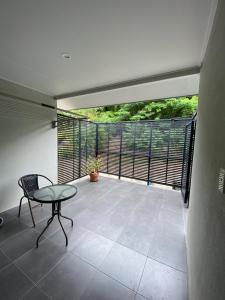 a balcony with a glass table and a chair at Cooktown Harbour View Luxury Apartments in Cooktown