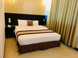 1 dormitorio con 1 cama grande en una habitación de hotel en My Inn Hotel Lahad Datu, Sabah, en Lahad Datu