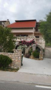 ein Gebäude mit einer Steinmauer mit Blumen darauf in der Unterkunft Ruža in Skradin