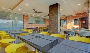 Treebo Trend Golden Heights في جمشيدبور: غرفة طعام مع طاولات وكراسي صفراء