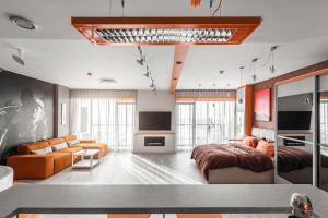 a bedroom with a bed and a living room at sky ORANGE jacuzzi sauna 28 FLOOR in Klaipėda
