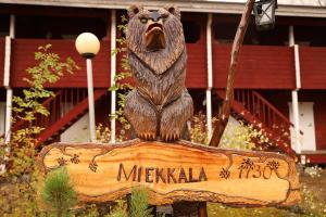 a statue of a bear sitting on top of a sign at Miekkalan Saunatupa in Lappeenranta