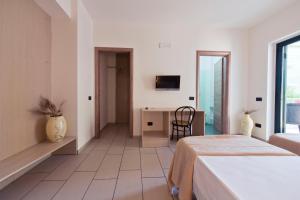 a bedroom with a bed and a desk and a television at Longomare in Corigliano Calabro