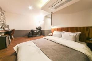 um quarto com uma cama grande e uma secretária em Hotel Chicago em Changwon