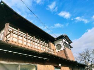 un edificio con un reloj al costado. en Guesthouse Sakichi, en Beppu