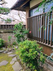 a porch with a fence next to a garden at Guesthouse Sakichi in Beppu