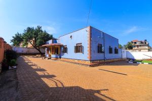 a small building on a brick road with a blue at Jinja Grand Hotel in Jinja