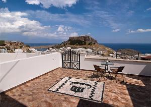 un patio con tavolo, sedie e vista sull'oceano di Lindos Panorama a Líndos