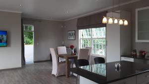 a kitchen and dining room with a table and chairs at Versailles in Pretoria