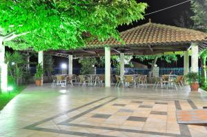 a pavilion with chairs and tables in a courtyard at night at Panorama Hotel in Ammoudia