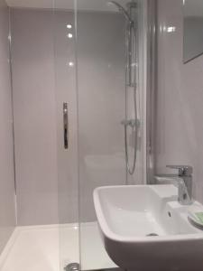 a bathroom with a sink, mirror and bath tub at Crossroads House in Carlisle