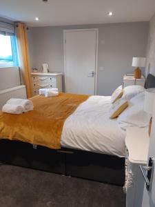 een slaapkamer met een groot bed en handdoeken bij Crossroads House in Carlisle