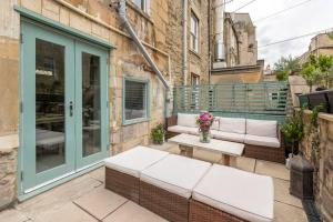 eine Terrasse mit einem weißen Sofa und einem Tisch in der Unterkunft Lovely 4 Bedroom townhouse in Bath