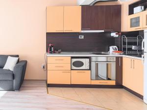 a kitchen with a microwave and a couch in a room at Like home in Burgas City
