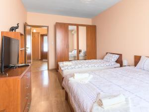 a hotel room with two beds and a television at Like home in Burgas