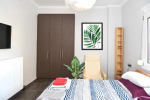 a bedroom with a bed and a plant in it at Modern apartment in the heart of the city in Larisa