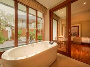 a large bathroom with a tub and a bedroom at Agra & Amurti Villas in Munggu +35 photos