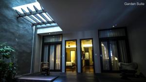 The Ranee Boutique Suites في كوتشينغ: غرفة بأبواب زجاجية وسقف