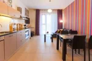 a kitchen and living room with a table and a couch at Apartamenty Świnoujście - Baltic Park in Świnoujście