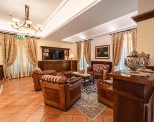 sala de estar con muebles de cuero y TV en Hotel Casal Dell'Angelo, en Marigliano