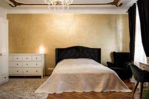 a bedroom with a bed and a chandelier at Concert Hall boutique apartment in Cēsis