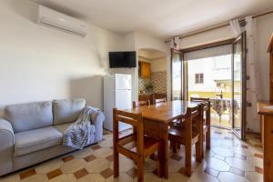 sala de estar con mesa y sofá en Red Passion Beach, en Alghero