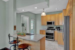 a kitchen with wooden cabinets and a counter with stools at Oakley Square 3BR Charmer - Total Walkability home in Cincinnati