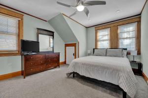 a bedroom with a bed and a flat screen tv at Oakley Square 3BR Charmer - Total Walkability home in Cincinnati