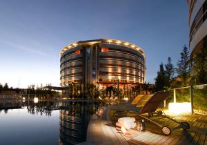 a building with a bench next to a body of water at Hotel Abades Nevada Palace in Granada