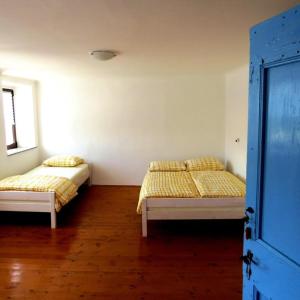 two beds sitting in a room with wooden floors at Hiša Šucarija in Dutovlje