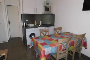 a kitchen with a table and chairs and a kitchen with a washing machine at MINI VILLA SANTA GIULIA in Porto-Vecchio