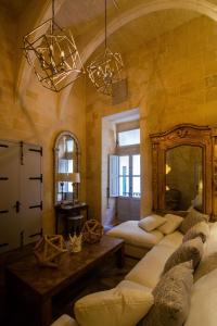 Sala de estar con 2 camas y espejo en Palazzino Birgu Host Family Bed and Breakfast en Vittoriosa