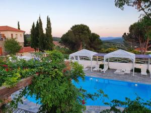 - Vistas a la piscina de un complejo con mesas y sillas en Lagou Raxi Country Hotel, en Lavkos