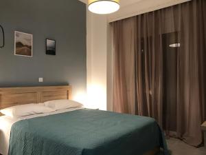 a bedroom with a bed and a lamp at Midway Point Apts in Heraklio