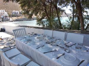 a white table with plates and silverware on it at Villa Kantouni by the sea in Kalymnos